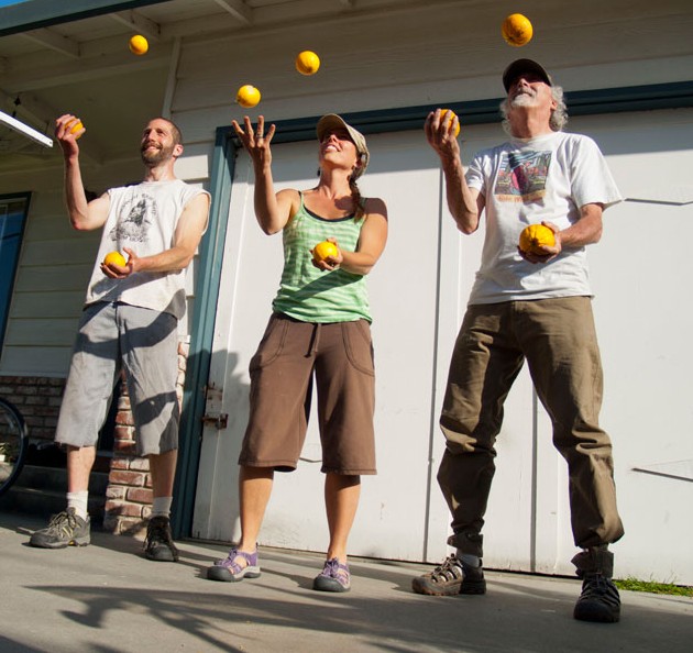 Steve Schnaar, (left), founder of Santa Cruz Fruit Tree Project juggles fruit with two volunteers. Photo by Bradley Allen. 