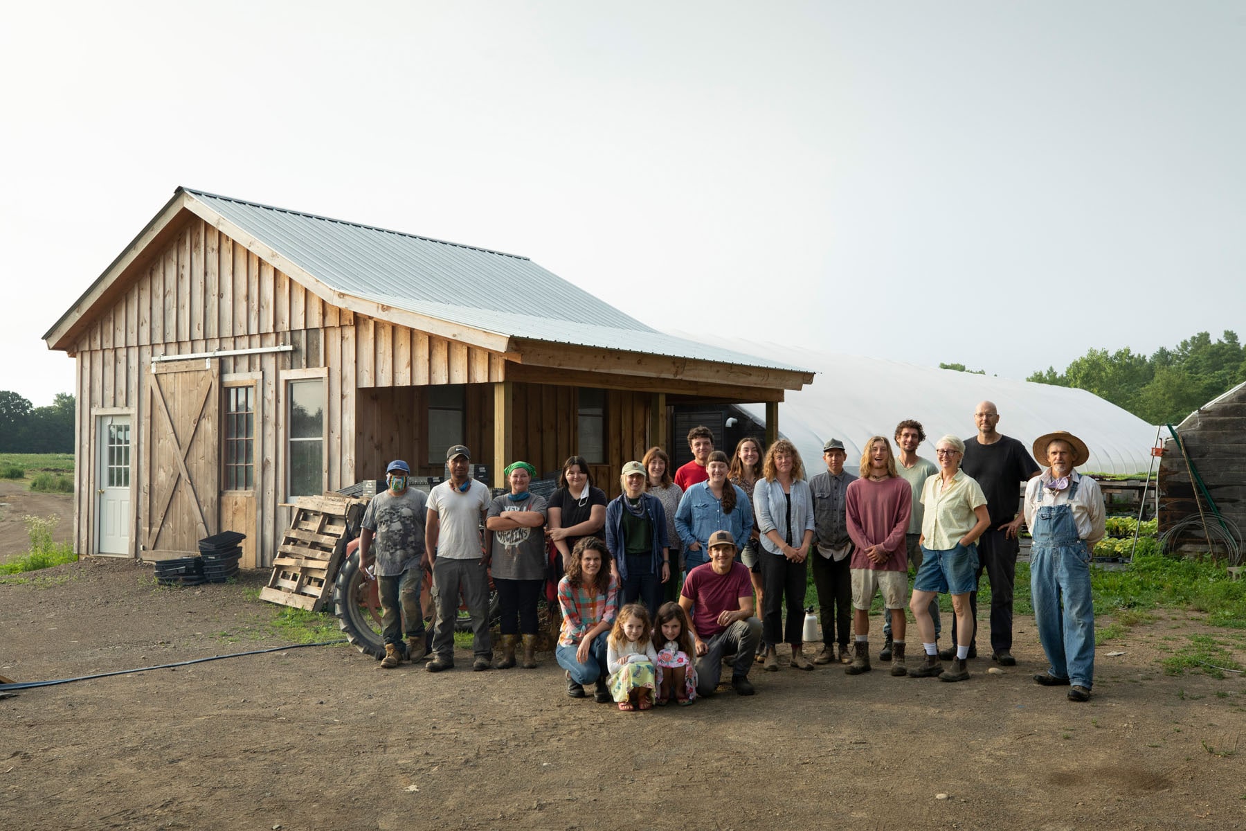 large group of farmers standing in front of a barn